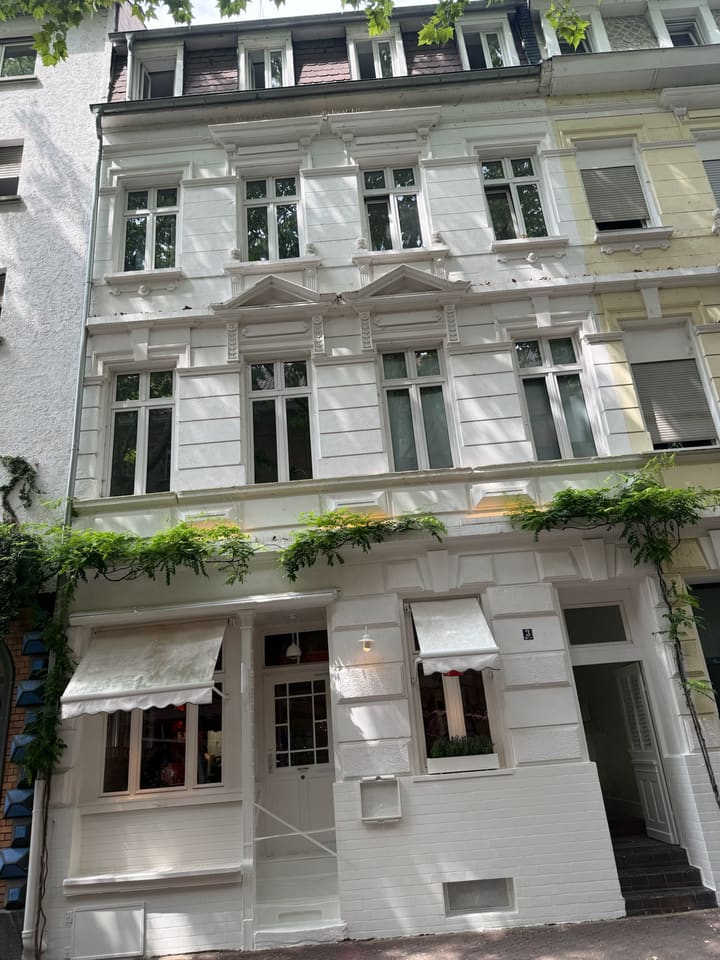 Weiße Altbaufassade des Hauses Beilstraße 3 mit Markisen im Erdgeschoss
