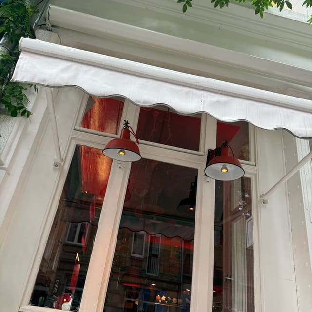 Fenster mit Markise und roten Lampen