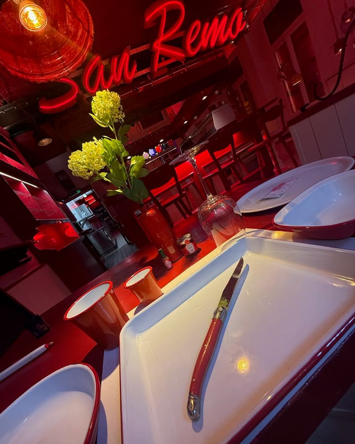 Tisch mit Blumen vor dem Neonschriftzug
