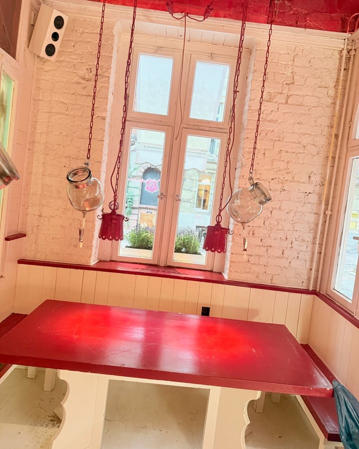 Fensterplatz mit rotem Tisch im Tageslicht