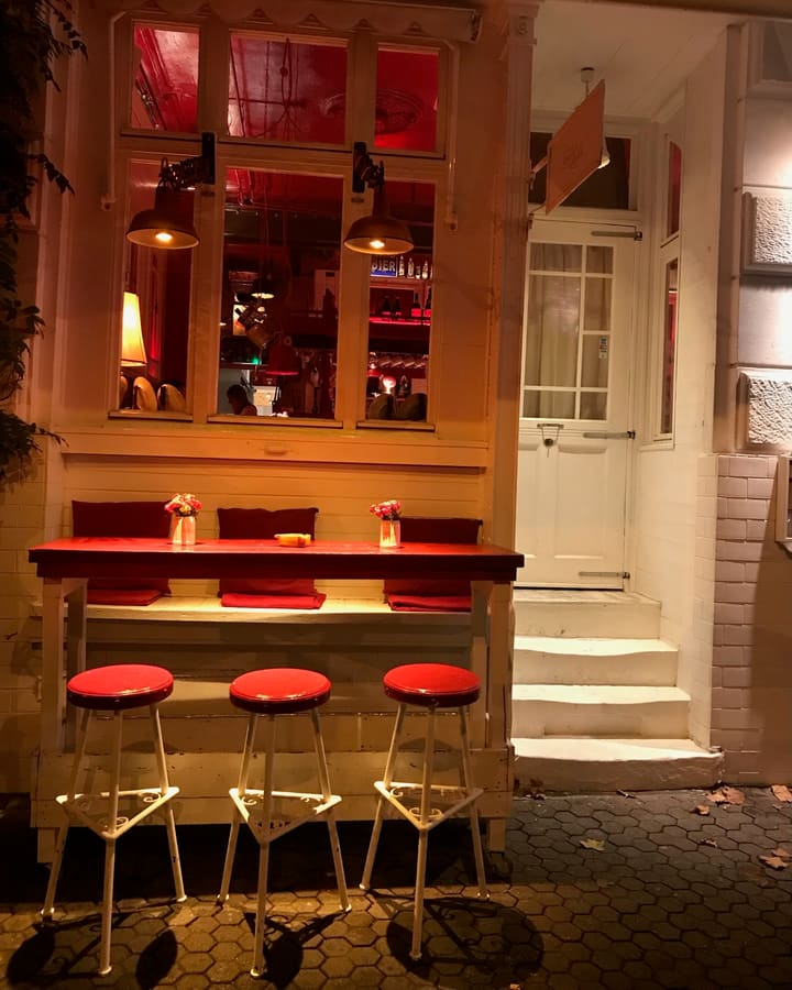 Fensterbar mit roten Hockern in warmem Licht